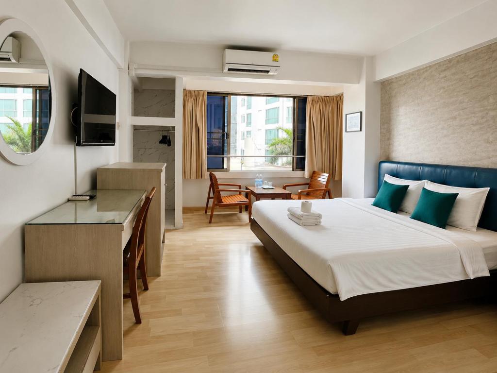 a hotel room with a bed and a desk at Crown BTS Nana Hotel in Bangkok