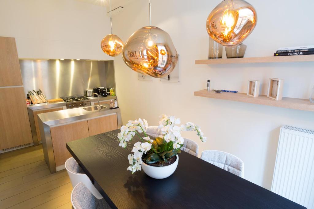 uma cozinha com uma mesa com um vaso de flores em Y & L villa em Antuérpia