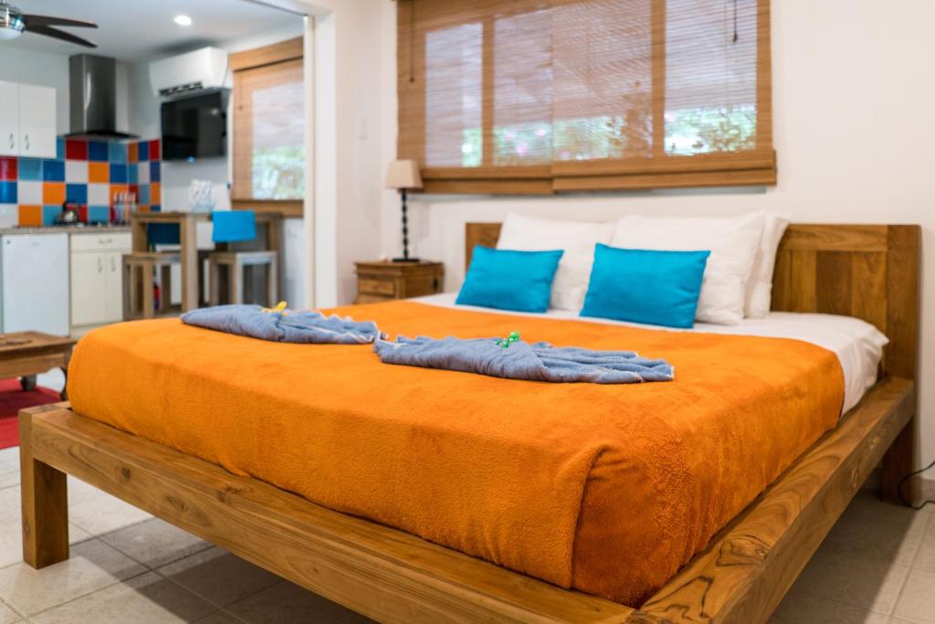 1 dormitorio con 1 cama grande con almohadas azules en Cas Elizabeth, en Palm-Eagle Beach