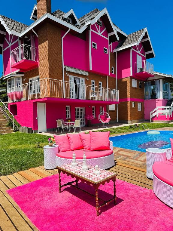 a pink house with a table in front of it at Pink Village Boutique in Campos do Jordão