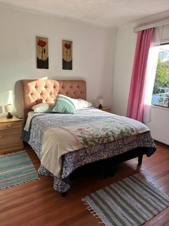 a bedroom with a bed with a headboard and a window at HOSTEL Gloria Economy in Viña del Mar