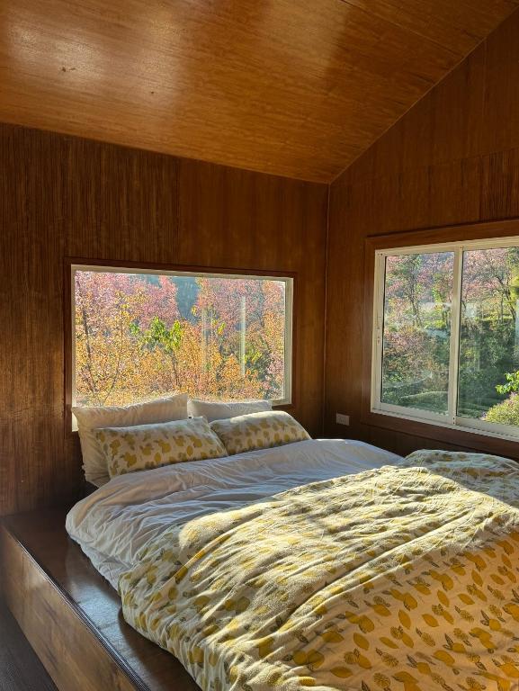 a large bed in a room with two windows at ไร่ชาดอยอินทนนท์ in Ban Yang Khun Wang