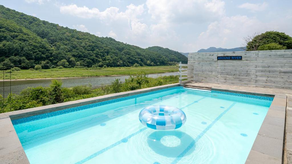 a swimming pool with a view of a river at Hongcheon Around River Poolvilla Pension in Mangdani