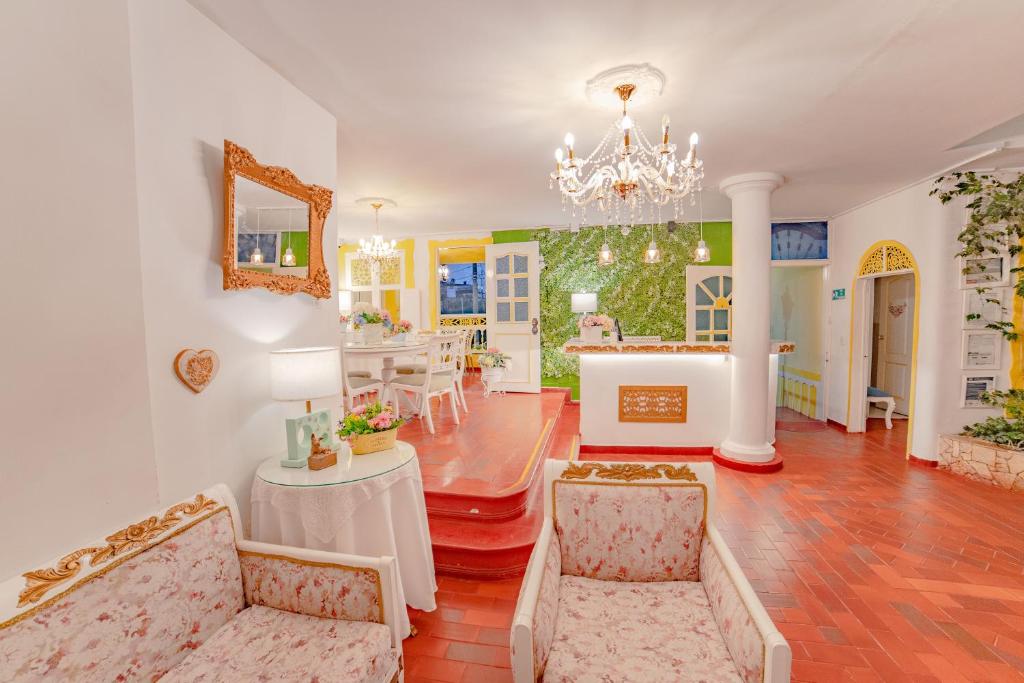 a living room with a chandelier and a dining room at Posada del Angel in Salento