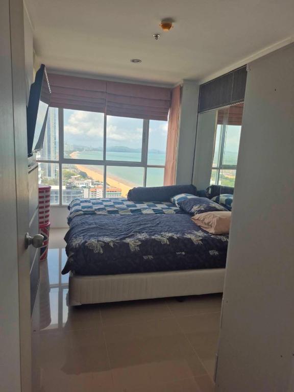 a bedroom with a bed and a large window at Beautiful 1bedroom 35sqm sea view floor17th jomtien Lumpini in Jomtien Beach