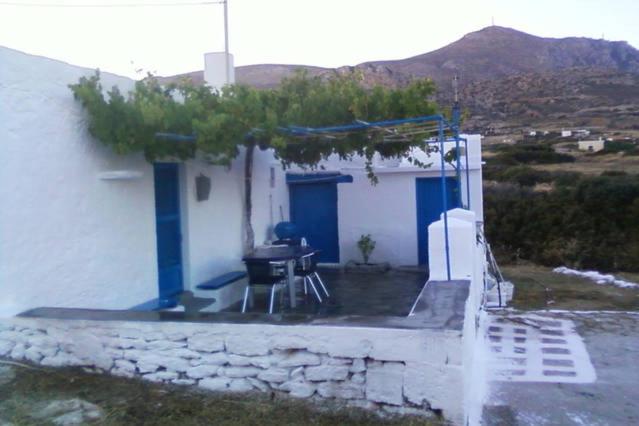 ein weißes Gebäude mit einem Grill davor in der Unterkunft Tinas House in Afiartis