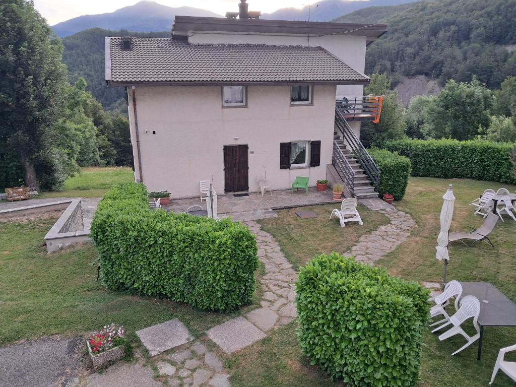 a small white house with a yard with bushes at Appartamenti Bice Abetone in Abetone
