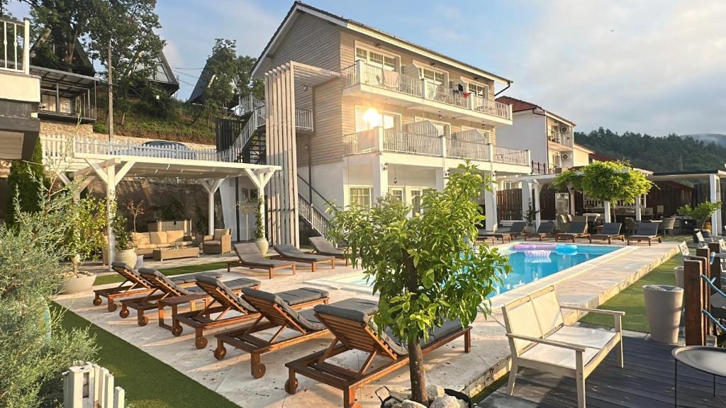 a house with a swimming pool and a bunch of chairs at Serenity in Eşelniţa
