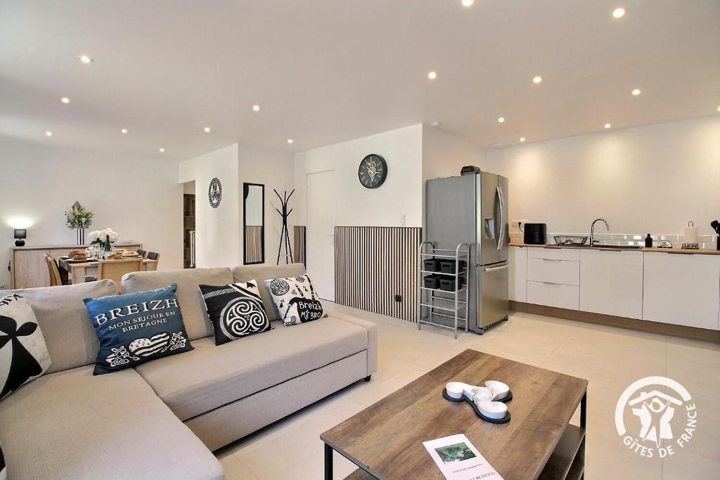 a living room with a couch and a kitchen at De la roche in Langourla
