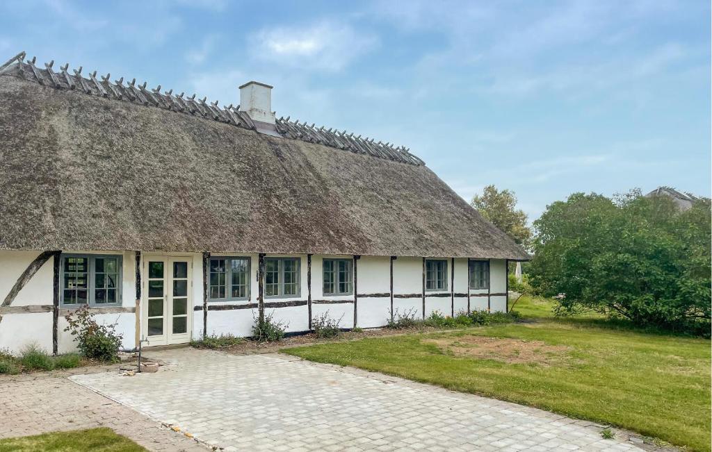 an old building with a thatched roof with a grass at Beautiful Home In Øster Ulslev With Wifi in Øster Ulslev