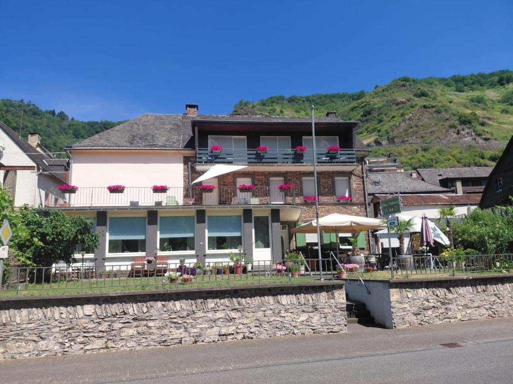 a building with chairs and tables in front of it at B&B Haus Valmosa in Valwig