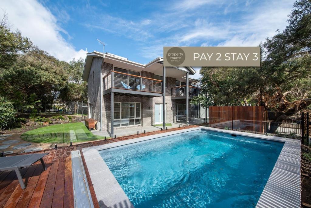 a swimming pool in front of a house at Gawalla Escape with Pool in Rye in Rye