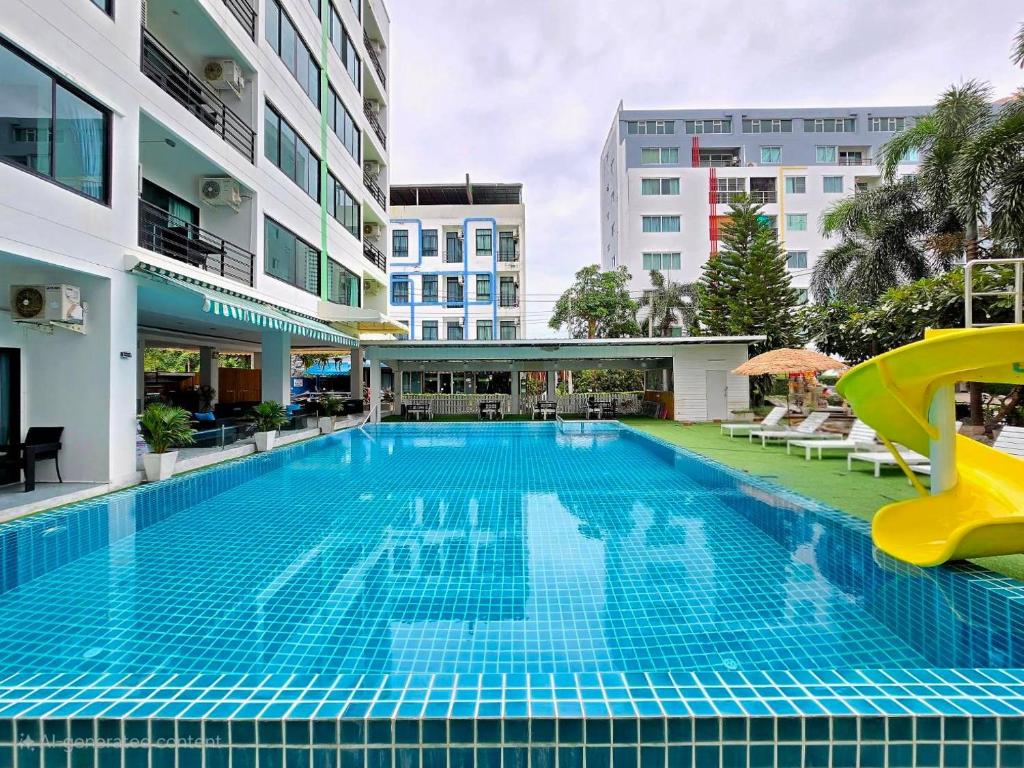 a pool at a hotel with a slide at The Regizt Jomtien Pattaya in Jomtien Beach