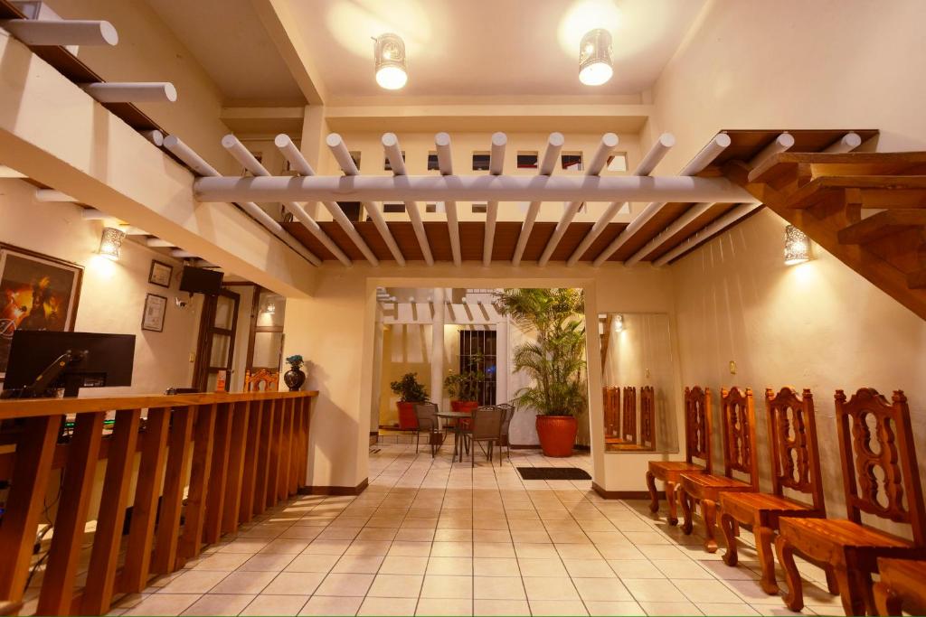 a church hallway with wooden pews and a altar at HOTEL NIUT-JA in Oaxaca City