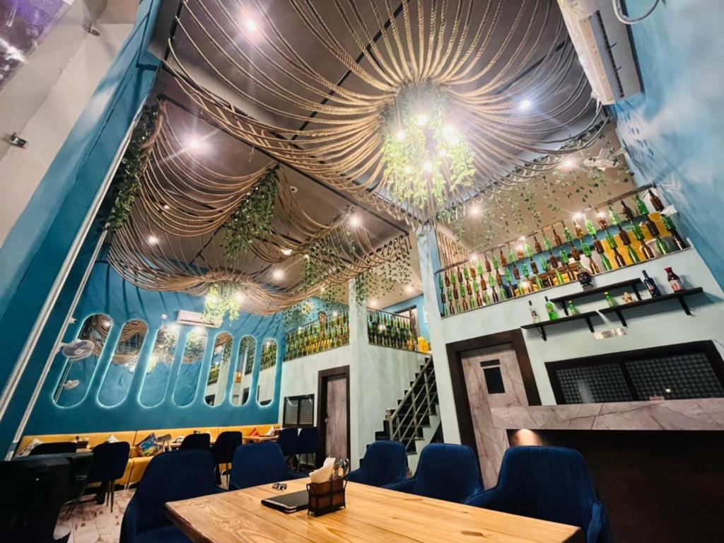 a dining room with a table and blue chairs at The Nines Hotel & Restro in Kālādhūngi