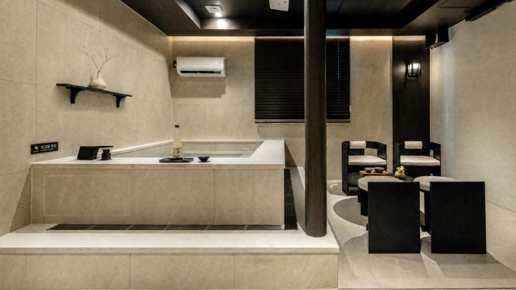 a bathroom with a sink and a counter with chairs at Anook Hotel Ulsan Samsan in Ulsan