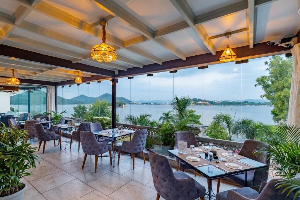 a restaurant with tables and chairs and a view of the water at Panna Vilas - A Lake Facing Boutique Hotel in Udaipur