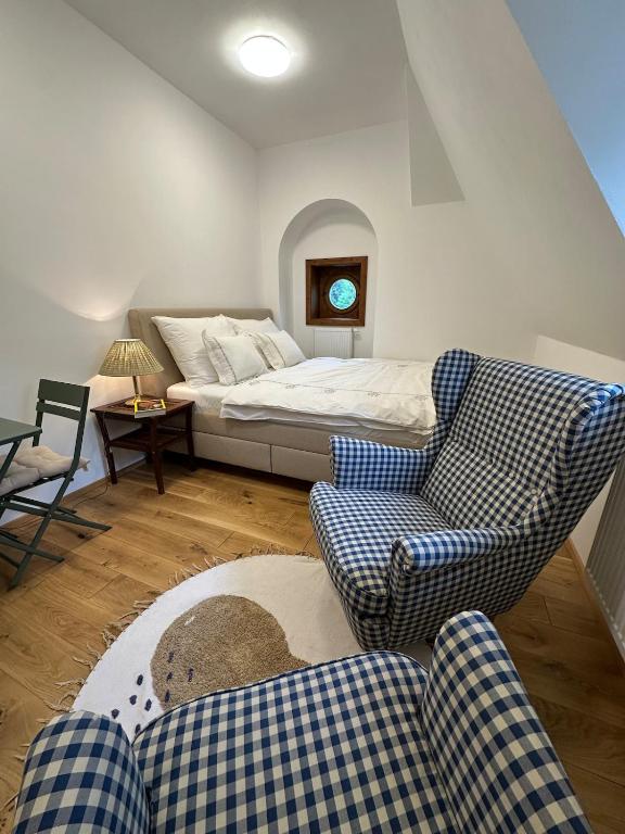 a living room with a bed and two chairs at Apartmán - Ostrůvek 203 in Lesná