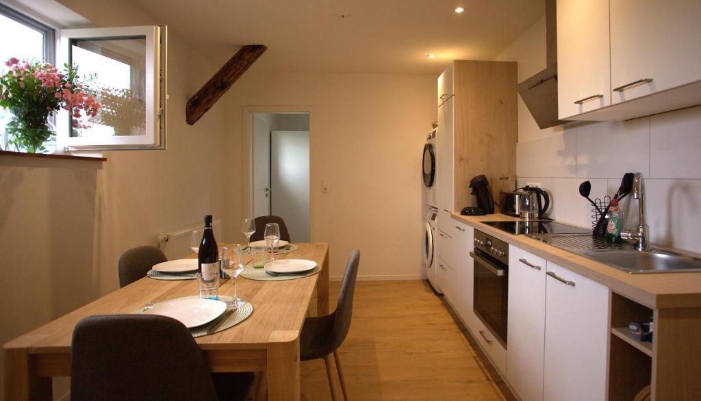 a kitchen with a wooden table with two chairs and a tableablish at Trüffelhof 2 in Bodman-Ludwigshafen