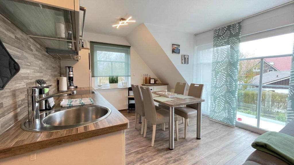 a kitchen with a sink and a table with chairs at Strandbox & Strandresidenz in Norderney