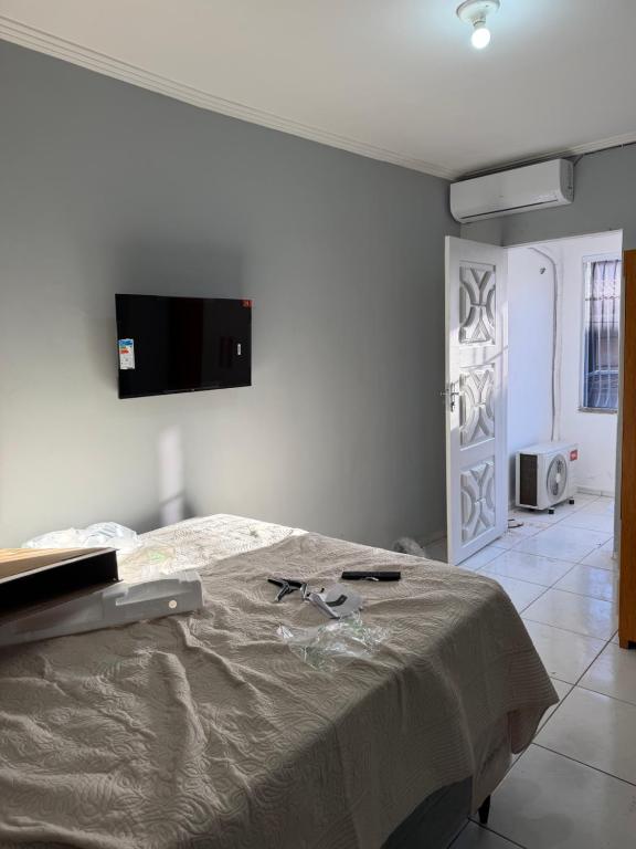 a bedroom with a bed and a tv on the wall at Residencial js in Fortaleza