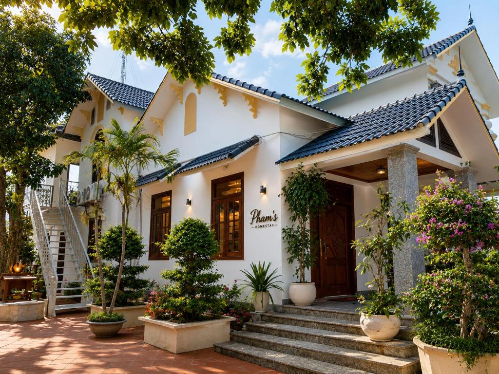 a white house with stairs and plants at Pham's Homestay in Île de Trà Cổ