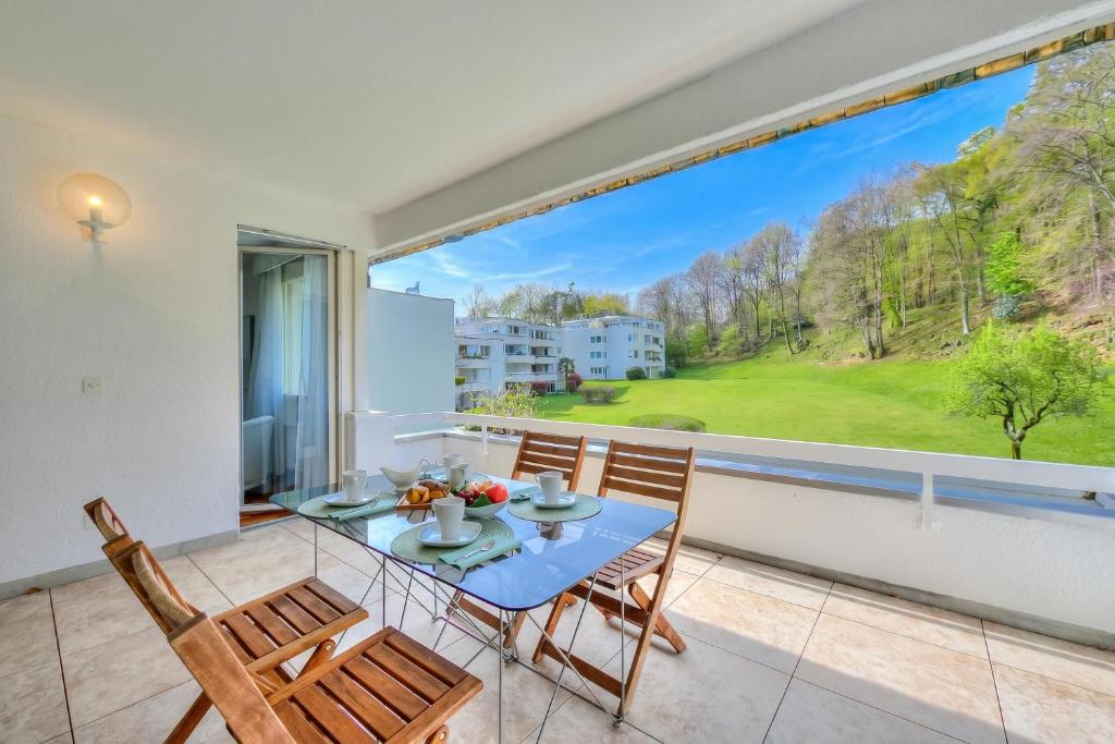 a dining room with a table and chairs and a large window at Residenza Parco Carona with Lake-View - Happy Rentals in Lugano