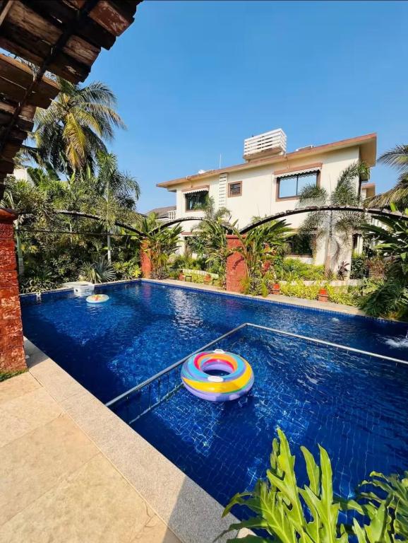 a swimming pool with a toy in front of a house at 4BHK Villa in Anjuna with Jacuzzi & Pool in Anjuna