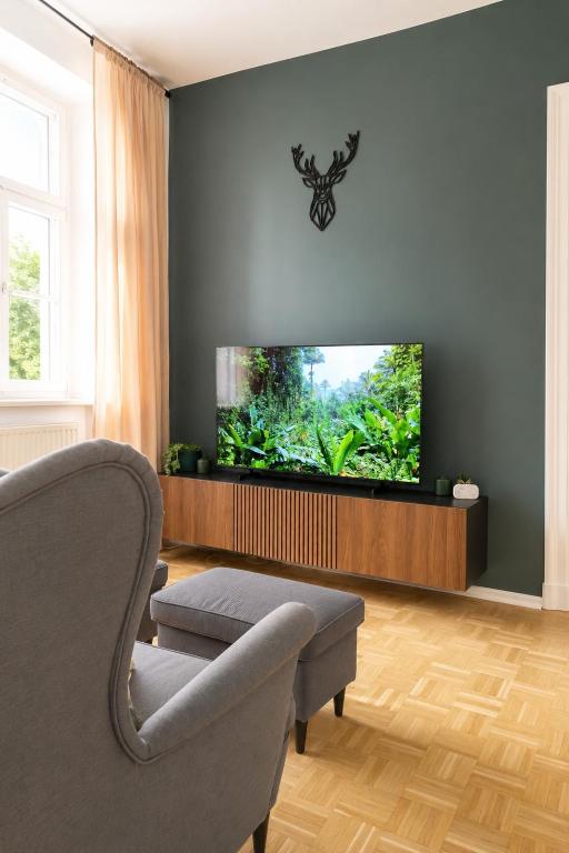 a living room with a couch and a flat screen tv at Gera Apartment Green in Gera