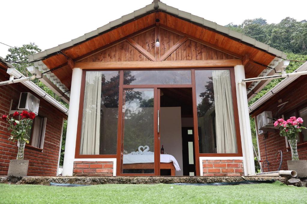 a house with a glass door with a bed in it at LAS 7 CASCADAS Campground - Restaurant - Lodge in Cacaoal
