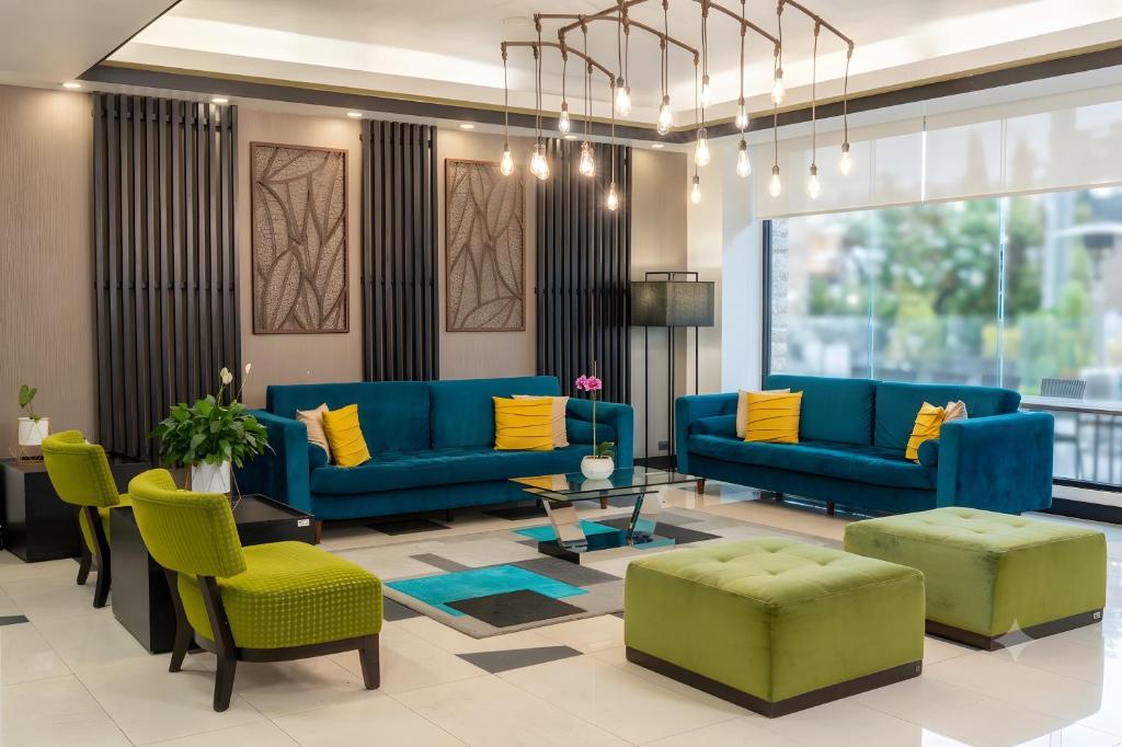 a lobby with blue couches and yellow pillows at Wyndham Garden Quito in Quito