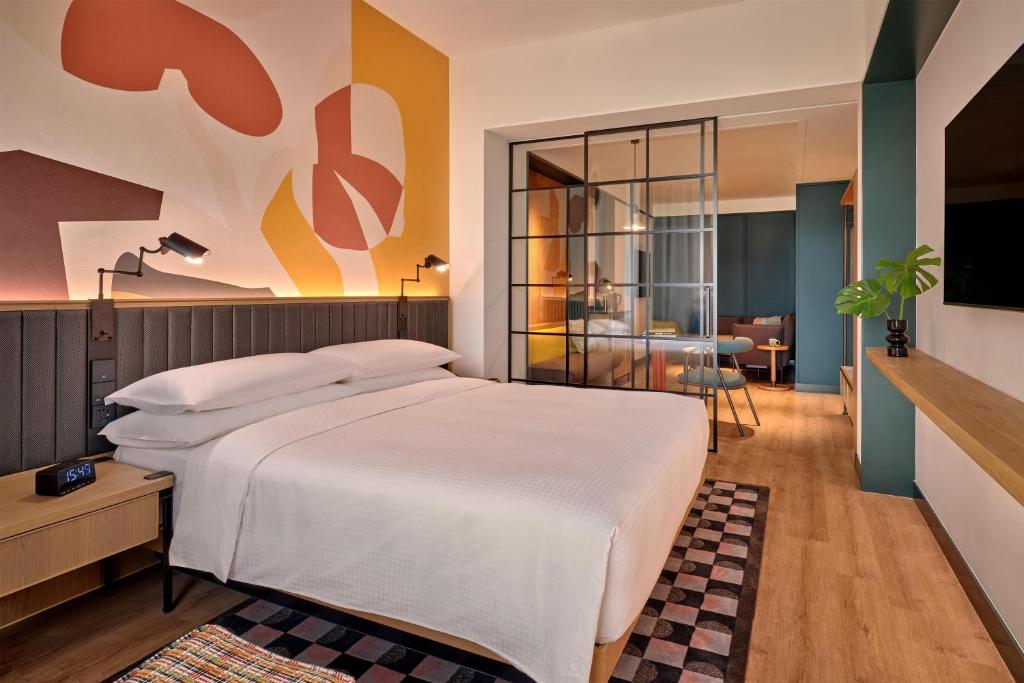 a bedroom with a large bed and a living room at Caption by Hyatt Zhongshan Park Shanghai in Shanghai