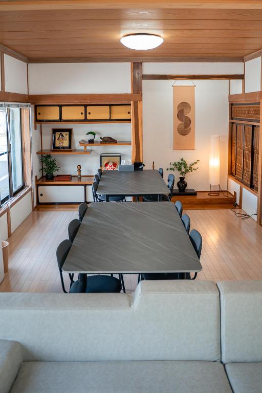a meeting room with two tables and chairs at The Alpen House Omachi in Omachi