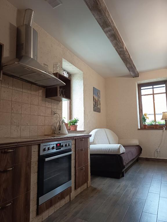 a kitchen with a stove and a bed in a room at Gościniec Villa Romana in Piecki