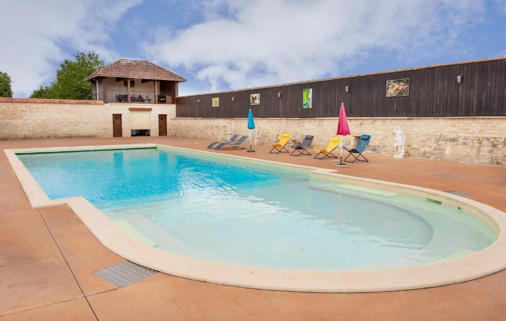 a large swimming pool with chairs and umbrellas at Amazing Home In Lonnes With Heated Swimming Pool in Lonnes