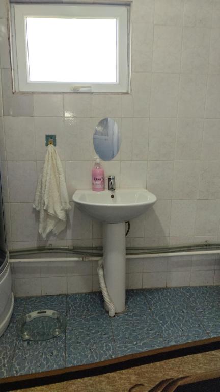 a bathroom with a sink and a window at Akmuz House in Ak-Muz