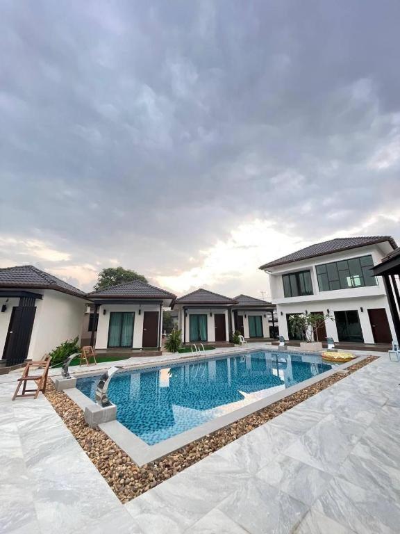 a swimming pool in front of a house at Smilang Chalet in Kuala Terengganu