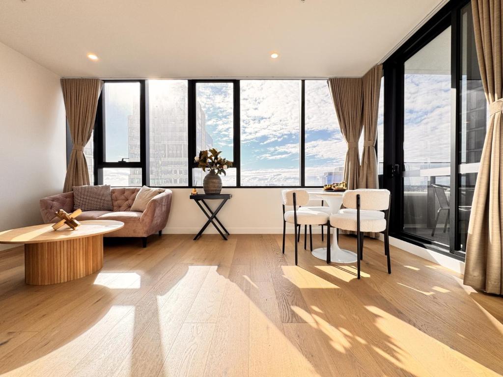 a living room with a couch and a table and chairs at Skyline Views Premium 2B2B Free Parking Box Hill in Box Hill