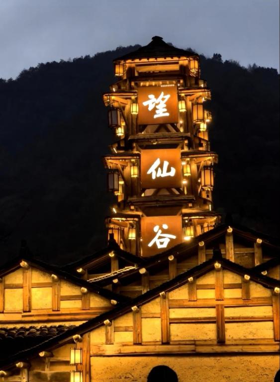 a clock tower on top of a building at night at Wangxian Shanshe Homestay B&B-Wangxian Valley Scenic Area in Qiaotou