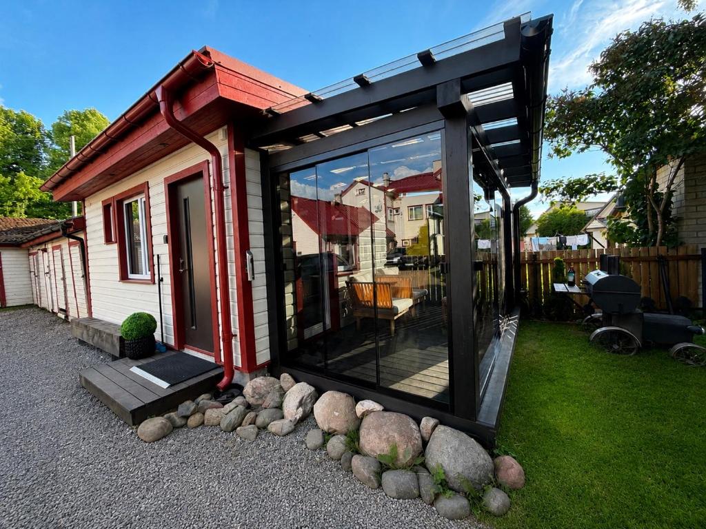 a small house with a large window and some rocks at Pärnu Summer Studio in Pärnu