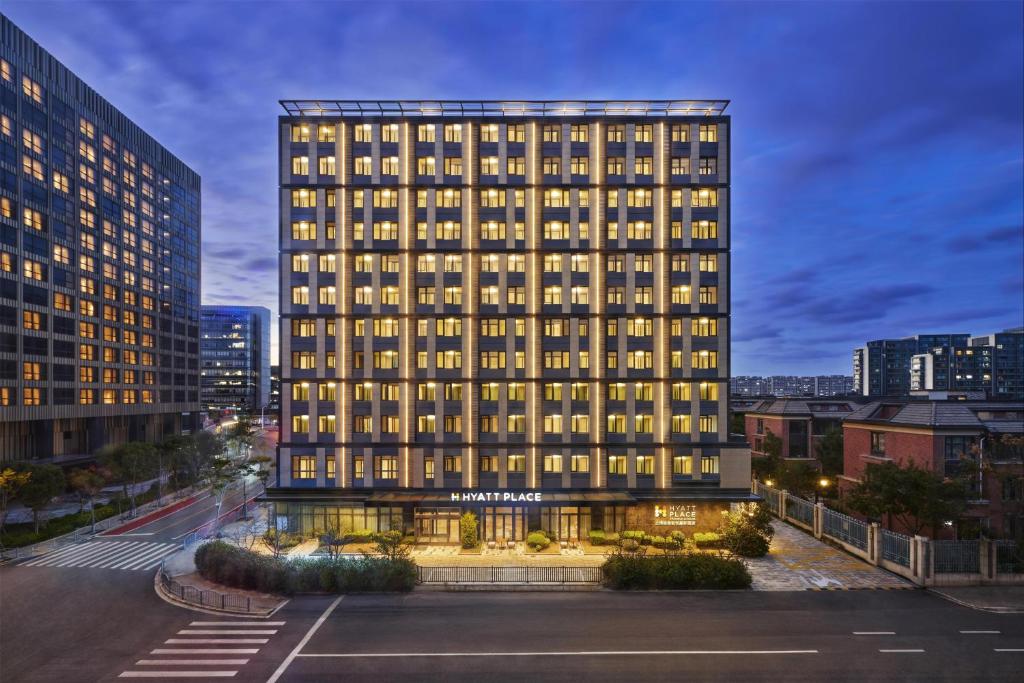 a tall building with many windows in a city at Hyatt Place Shanghai Lingang in Zhenghai