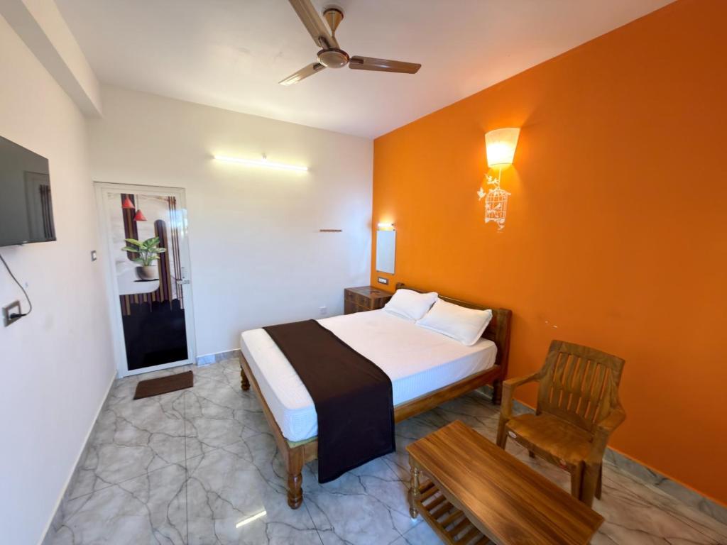 a bedroom with a large bed and a chair at Gravity Groups Core - Sivadurai Residency in Puducherry Airpoert