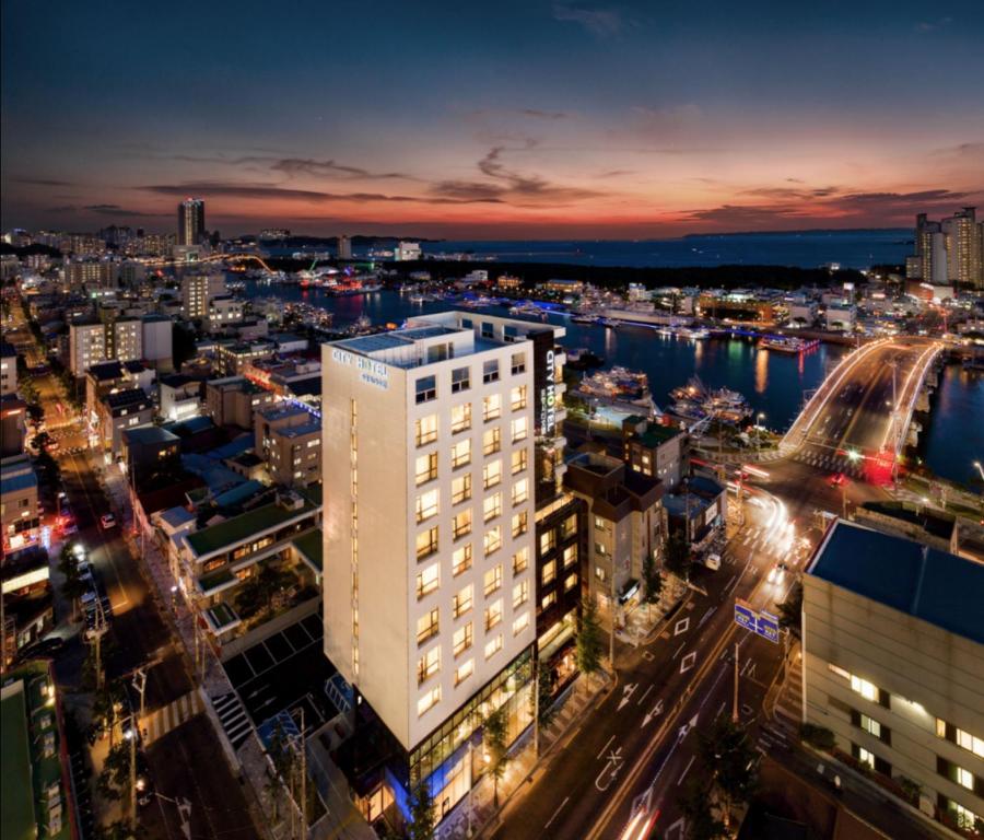 a city skyline at night with a tall white building at 포항시티호텔 in Pohang