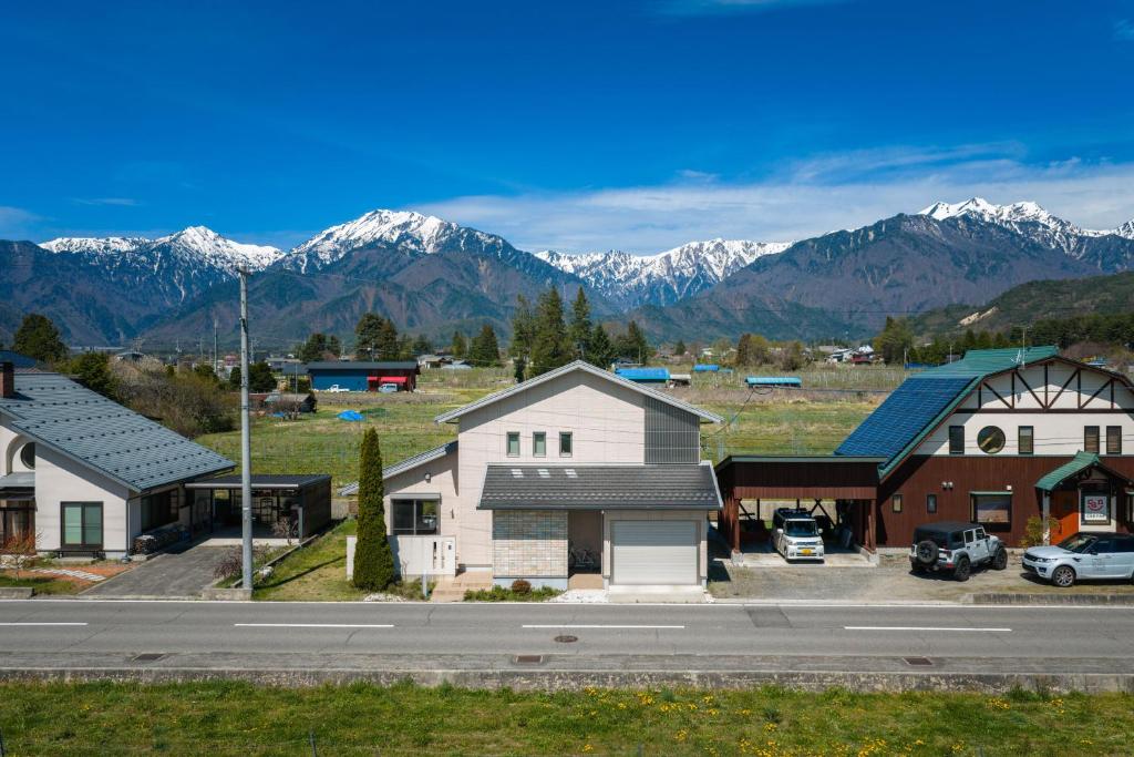 a small town with snow capped mountains in the background at Zekkei in Omachi