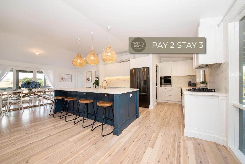 a kitchen and dining room with a blue island in a room at Dundas on the Beach at St Andrews in Saint Andrews Beach