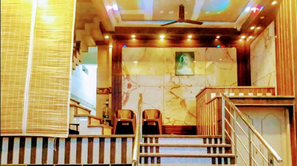 a staircase in a building with two chairs at Olive inn in Kanyakumari