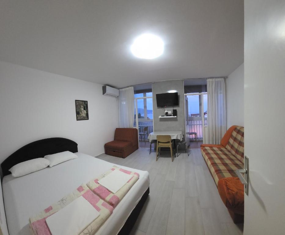 a bedroom with a bed and a living room at Garsonjera - centar Igalo in Igalo