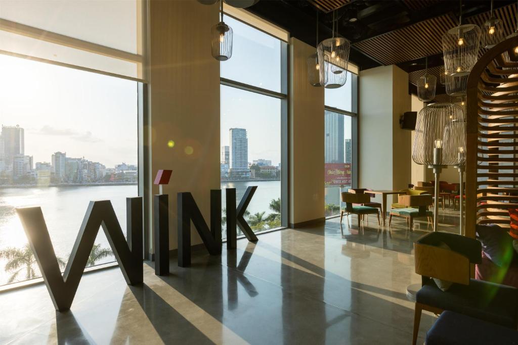 a dining room with a view of the water at Wink Danang Riverside, Unscripted by Hyatt - 24 Hours stay in Danang