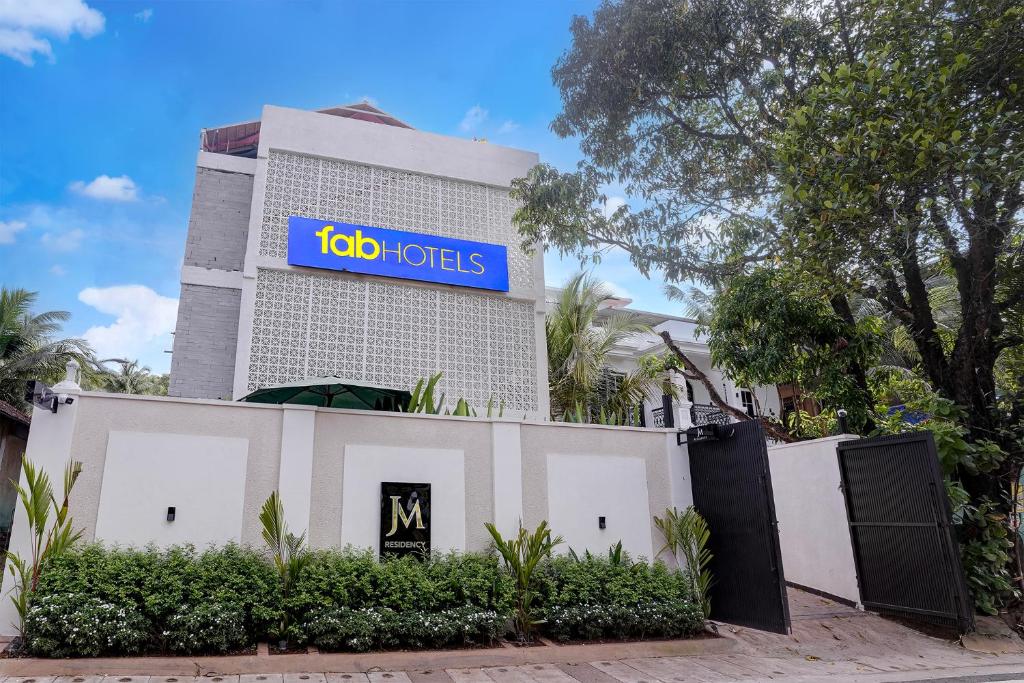 a building with a sign on top of it at FabHotel JM Residency in Mandrem