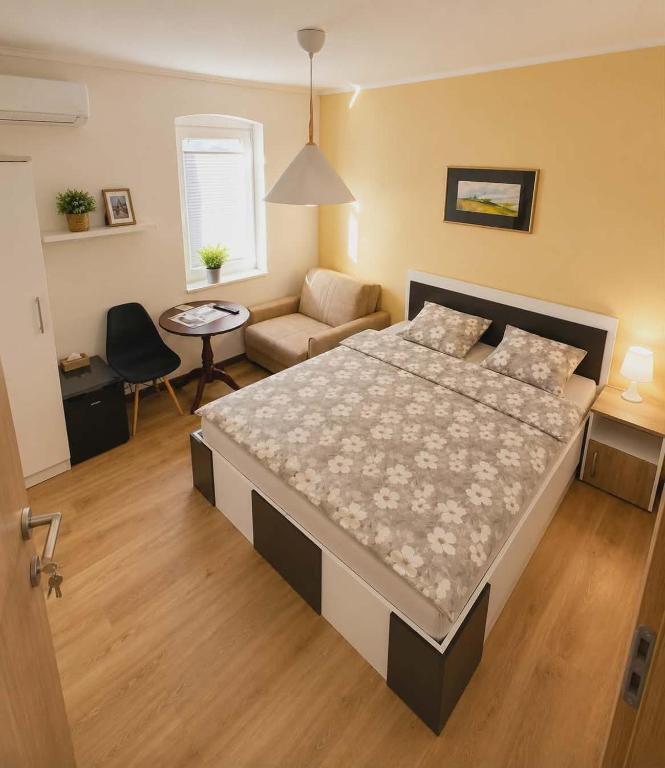 a bedroom with a large bed and a couch at 3 Stars Apartments in Prilep